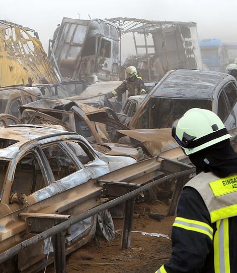 Feuerwehrleute sind am Freitag auf der Autobahn A19 bei Kavelstorf in der Nähe von Rostock bei einer Massenkarambolage im Einsatz. Bei einem Sandsturm fuhren in beiden Fahrtrichtungen Dutzende Fahrzeuge und LKW ineinander und brannten teilweise aus.
