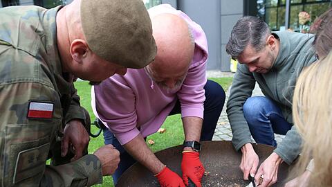 Feuer machen mit Birkenrinde: Das lernen Mitarbeiter der deutschen Botschaft in Warschau bei Notfalltraining von Polens Armee.