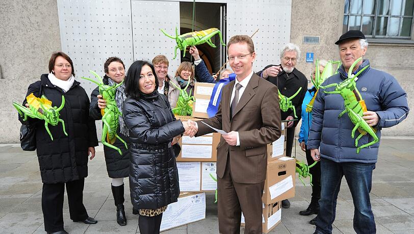 Grüne Plastik-Heuschrecken als Warnung: Ministerialrat Horst Wonka nimmt die Unterschriften vor der Staatskanzlei entgegen. Grüne Plastik-Heuschrecken als Warnung: Ministerialrat Horst Wonka nimmt die Unterschriften vor der Staatskanzlei entgegen.