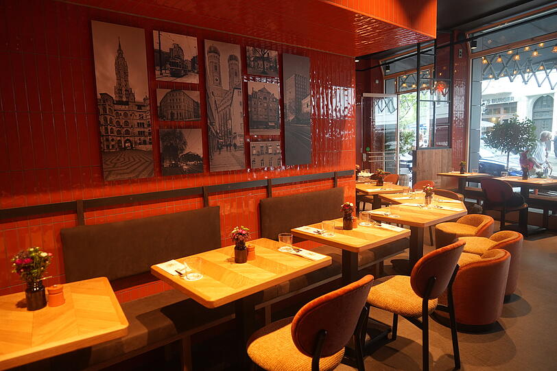 Orange-rote Kacheln, Holztische und historische Bilder an der Wand machen die Vollaths Pizza Bar aus.