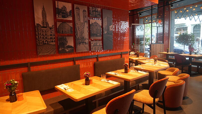 Orange-rote Kacheln, Holztische und historische Bilder an der Wand machen die Vollaths Pizza Bar aus.