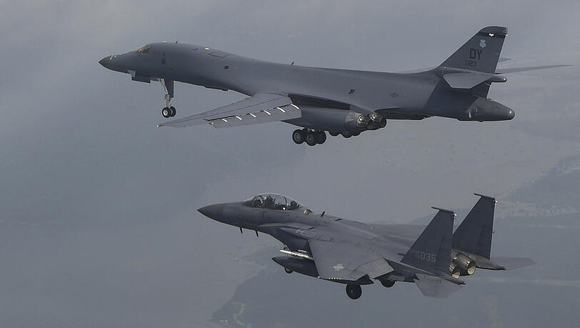 Ein amerikanisches B-1-Kampfflugzeug (oben) und eine südkoreanische F-15K fliegen während eines gemeinsamen Manövers über der Osan Air Base in Pyeongtaek. Ein amerikanisches B-1-Kampfflugzeug (oben) und eine südkoreanische F-15K fliegen während eines gemeinsamen Manövers über der Osan Air Base in Pyeongtaek.