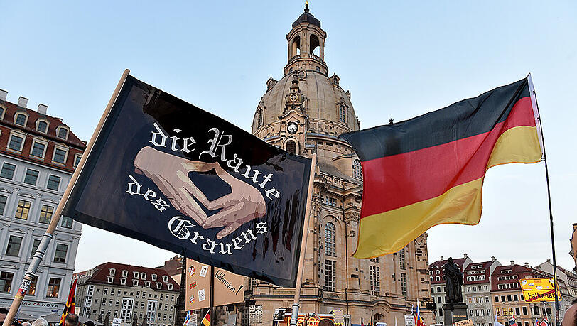 Mehrere tausend Pegida Anhänger demonstrieren am 05.10.2015 in Dresden (Sachsen) auf dem neuen Markt vor der Frauenkirche. Auf einem Banner ist die "Raute des Grauen" zu sehen. Mehrere tausend Pegida Anhänger demonstrieren am 05.10.2015 in Dresden (Sachsen) auf dem neuen Markt vor der Frauenkirche. Auf einem Banner ist die "Raute des Grauen" zu sehen.