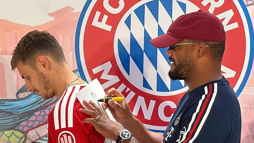 Trainer Vincent Kompany (r) malt - und Josip Stanisic muss raten.