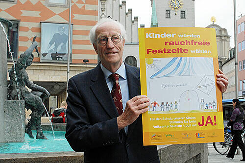 Friedrich Wiebel, Vorsitzender des Ärztlichen Arbeitskreises Rauchen und Gesundheit e.V., präsentiert das neue Plakat für das Rauchverbot