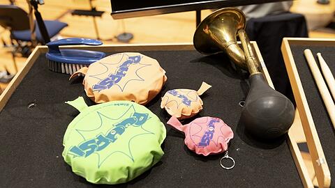 In der Neuen Musik kann alles zum Instrument werden: Furzkissen in verschiedener Größe nebst einer Autohupe und einer Bürste auf dem Tischchen eines Schlagzeugers des BR-Symphonieorchesters im Konzert der musica viva.
