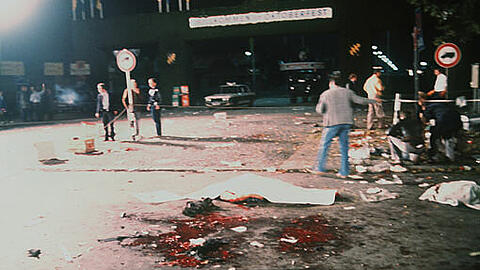 Das Archivbild vom 26.09.1980 zeigt mit Tüchern zugedeckte Todesopfer neben Blutlachen am Tatort des nächtlichen Bomben-Anschlages auf dem Münchner Oktoberfest.