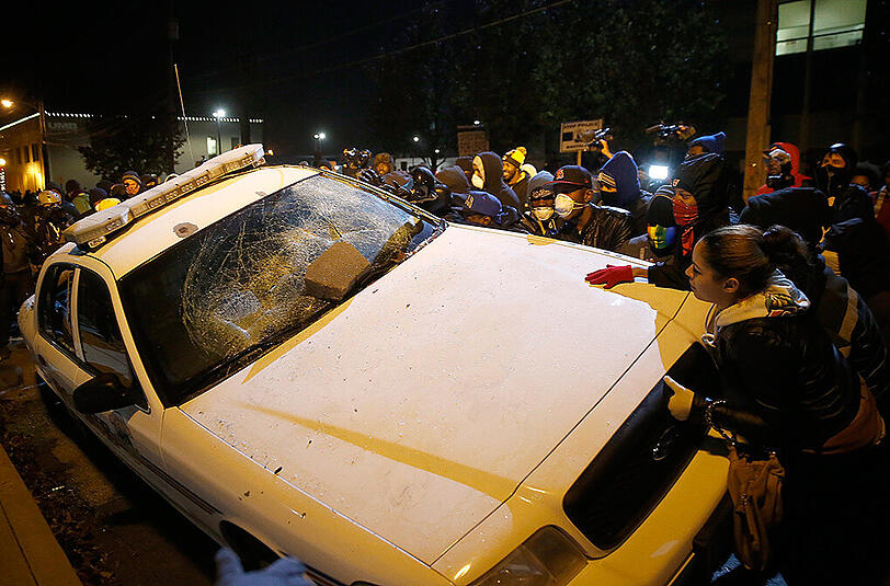Wütende Demonstranten zerstören ein Polizeiauto in Ferguson. Im Vergleich zum Vortag blieb es aber überwiegend friedlich.