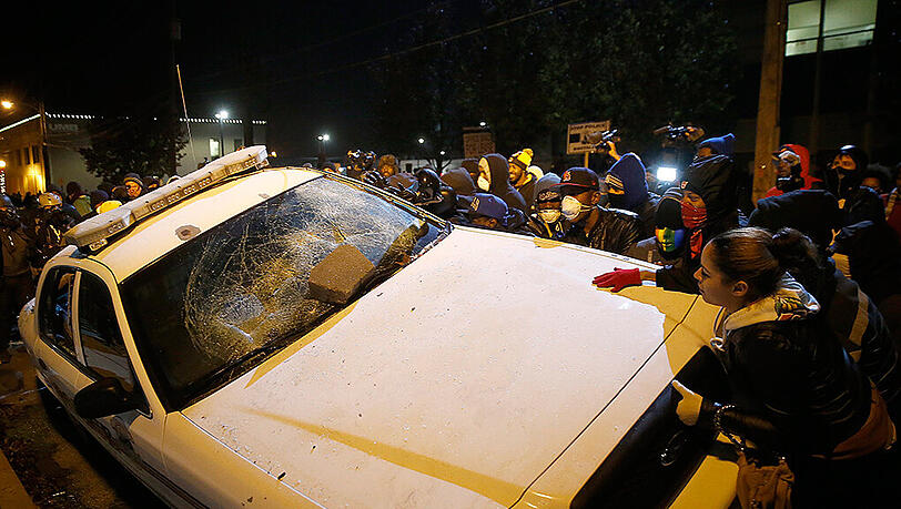 Wütende Demonstranten zerstören ein Polizeiauto in Ferguson. Im Vergleich zum Vortag blieb es aber überwiegend friedlich. Wütende Demonstranten zerstören ein Polizeiauto in Ferguson. Im Vergleich zum Vortag blieb es aber überwiegend friedlich.