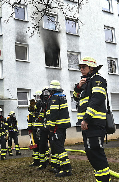 Einsatzkräfte der Feuerwehr vor der Brandwohnung. Einsatzkräfte der Feuerwehr vor der Brandwohnung.