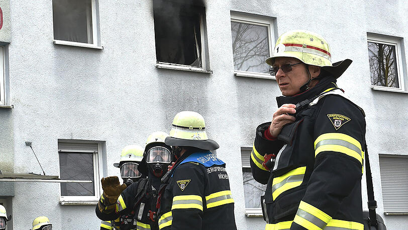 Einsatzkräfte der Feuerwehr vor der Brandwohnung. Einsatzkräfte der Feuerwehr vor der Brandwohnung.