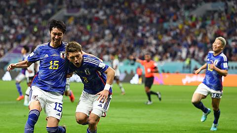 Ritsu Doan (M) von Japan jubelt  mit Daichi Kamada (l) nach seinem Treffer zum 1:1-Ausgleich.