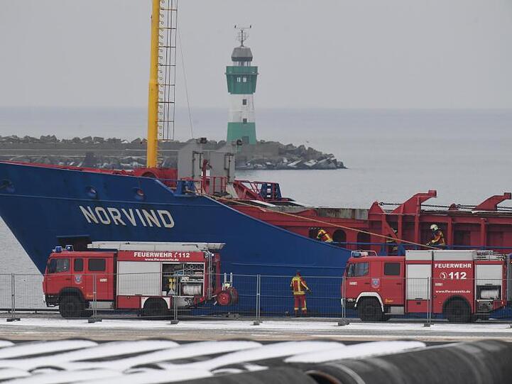Fahrzeuge der Einsatzkräfte stehen vor dem havarierten Stückgutfrachter "Norvind" im Hafen Sassnitz-Mukran.