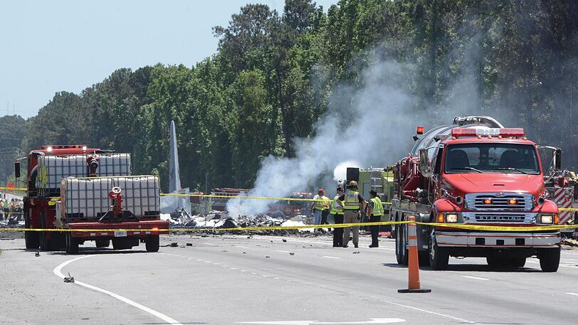 Feuerwehrleute sind an der Absturzstelle eines Transportflugzeugs vom Typ C-130 der US-Luftwaffe im Einsatz. Beim Absturz einer Militärmaschine im US-Bundesstaat Georgia sind mindestens fünf Menschen ums Leben gekommen.