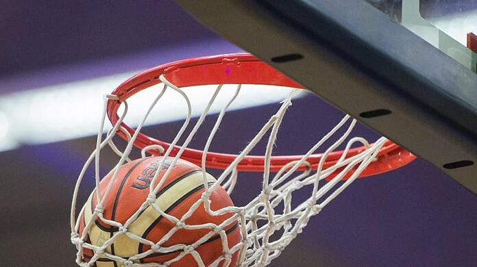 Ein Basketball fällt durch den Basketballkorb.