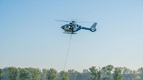 Noch immer fliegen Hubschrauber mit Wasserbehältern über das betroffene Waldgebiet.