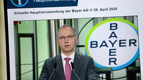 Auf einem Bildschirm ist Bayer Konzernchef Werner Baumann bei seiner Rede zu sehen.