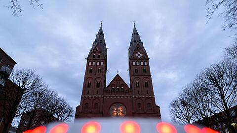 Graue Wolken ziehen über den St.-Marien-Dom auf dem Gelände des römisch-katholischen Erzbistums Hamburg. Erzbischof Heße hat dem Papst wegen Pflichtverletzungen bei der Aufarbeitung von Missbrauchsvorwürfen seinen Amtsverzicht angeboten.