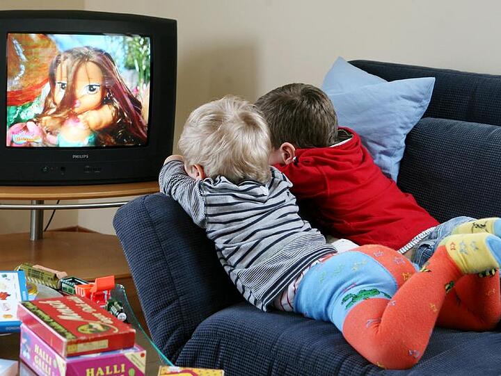 Kleine beim Fernsehen (Symbolbild). Bei dem Unfall in Rosenheim fiel ein Fernseher auf ein Einjähriges.