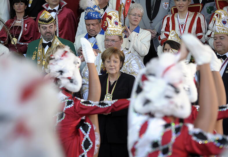 Die Bundeskanzlerin Angela Merkel betrachtet am Dienstag (22.02.11) in Berlin beim Empfang des Vereins Bund Deutscher Karneval (BDK) eine Tanzaufführung.