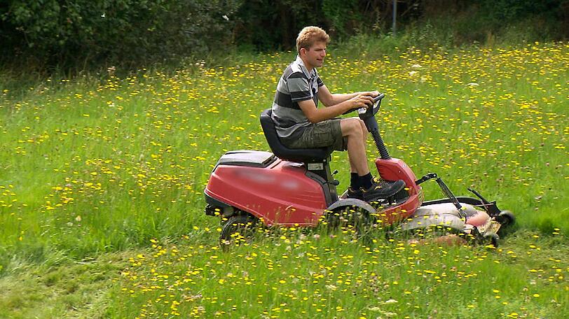 Hühner- und Schweinebauer Rolf (28) mäht für Janine ein Herz in die Wiese.