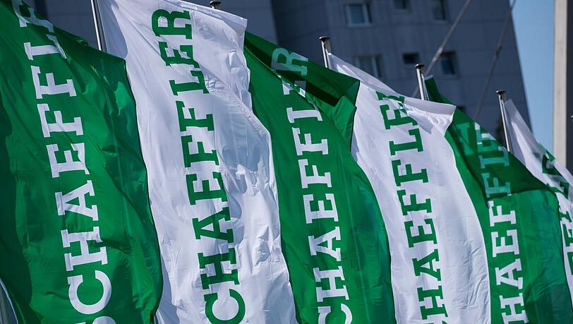 Fahnen mit dem Schriftzug der Schaeffler AG wehen vor der Firmenzentrale.