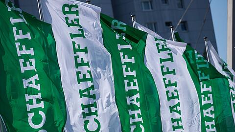 Fahnen mit dem Schriftzug der Schaeffler AG wehen vor der Firmenzentrale.