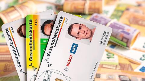 Hinter verschiedenen Gesundheitskarten liegen Geldscheine und B&uuml;ndel.