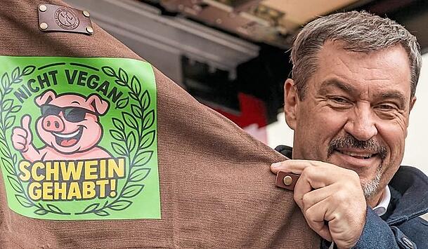 „Nicht vegan - Schwein gehabt!“ steht auf der Grillschürze, die Söder überreicht wurde. „Nicht vegan - Schwein gehabt!“ steht auf der Grillschürze, die Söder überreicht wurde.