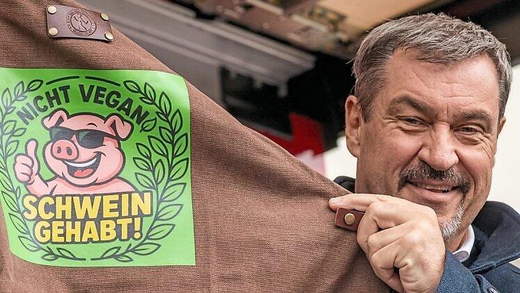 „Nicht vegan - Schwein gehabt!“ steht auf der Grillschürze, die Söder überreicht wurde. „Nicht vegan - Schwein gehabt!“ steht auf der Grillschürze, die Söder überreicht wurde.