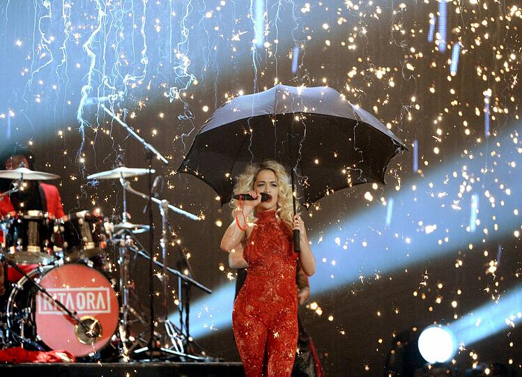 Von der Decke hingen
eine überdimensionale Glühbirne und ein riesiger Vogelkäfig, in dem
Sängerin Rita Ora für den ersten Liveauftritt des Abends
hinuntergelassen wurde.