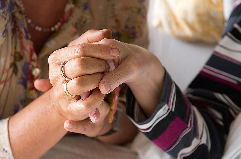 Eine Therapeutin hält im Hospiz St. Martin in Stuttgart die Hand einer todkranken Bewohnerin.