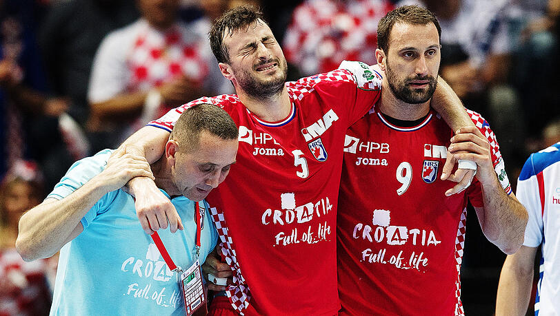 Kroatiens verletzter Spieler Domagoj Duvnjak (Mitte) wird von seinem Teamkollegen Igor Vori (rechts) vom Platz begleitet. Kroatiens verletzter Spieler Domagoj Duvnjak (Mitte) wird von seinem Teamkollegen Igor Vori (rechts) vom Platz begleitet.