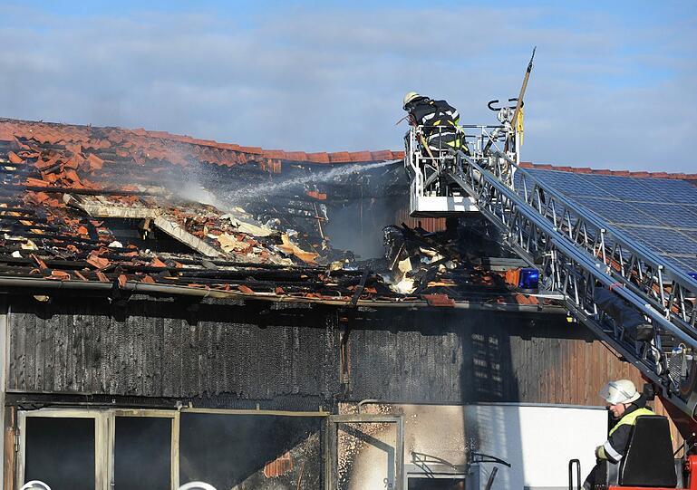 Feuerwehrleute löschen einen Brand an einem Wohn- und Geschäftshaus in Adelshofen (Landkreis Fürstenfeldbruck). Bei dem Brand entstand nach ersten Angaben ein Millionenschaden.