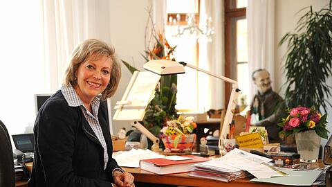 Christine Rauch an ihrem Schreibtisch. Im Hintergrund ist das oft fotografierte Ude-Double aus Pappmaché zu sehen.