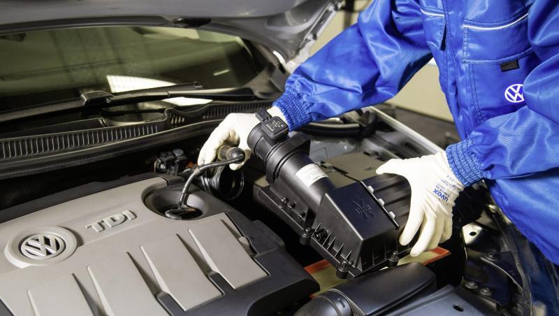 Ein VW-Mitarbeiter baut einen um einen Strömungsgleichrichter erweiterten Luftfilter in einen Dieselmotor der Typreihe EA 189 ein. Ein VW-Mitarbeiter baut einen um einen Strömungsgleichrichter erweiterten Luftfilter in einen Dieselmotor der Typreihe EA 189 ein.