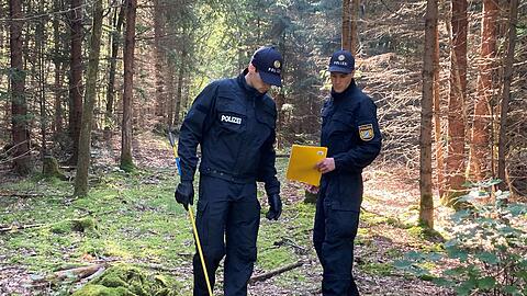 Zwei Polizisten stehen im Perlacher Forst.