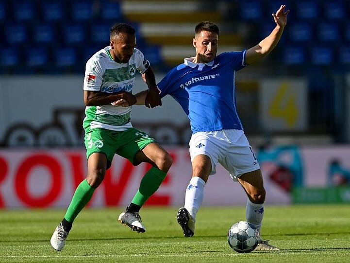 Der Fürther Julian Green (l) hält Fabian Schnellhardt im Zweikampf fest.