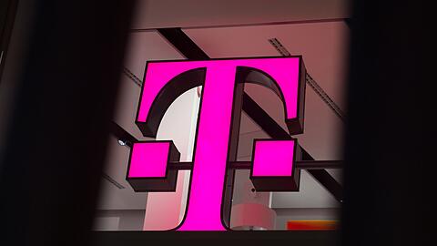 Ein Telekom-Logo strahlt in Magenta - f&uuml;r den Konzern sind die Beh&ouml;rdenpl&auml;ne eine gute Nachricht.
