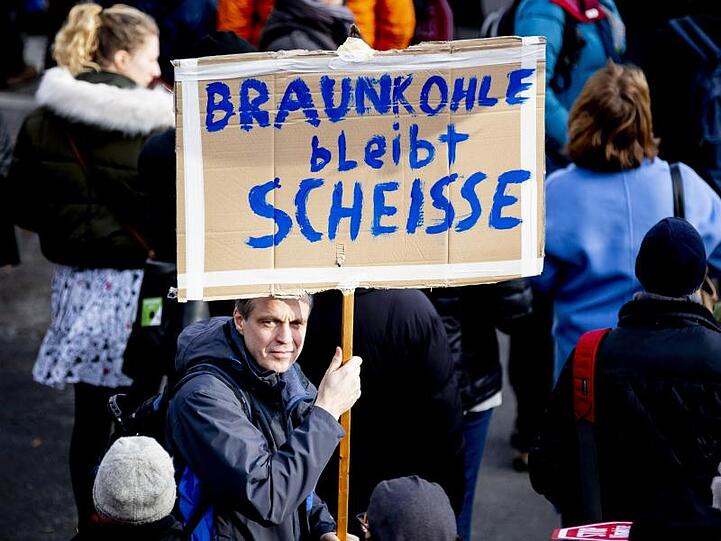 "Braunkohle bleibt Scheiße" steht auf dem Plakat eines Demonstranten in Berlin.