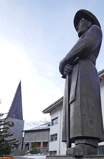Das Denkmal für Pfarrer Imseng auf dem Dorfplatz von Saas Fee.