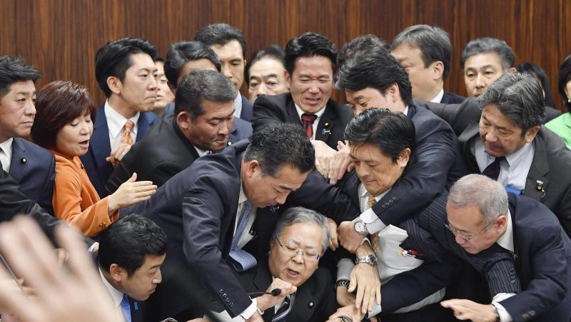 Handgemenge im japanischen Parlament: Mitglieder der Regierungspartei und der Opposition kämpfen in der Zuwanderungsdebatte um ein Mikrofon. Handgemenge im japanischen Parlament: Mitglieder der Regierungspartei und der Opposition kämpfen in der Zuwanderungsdebatte um ein Mikrofon.