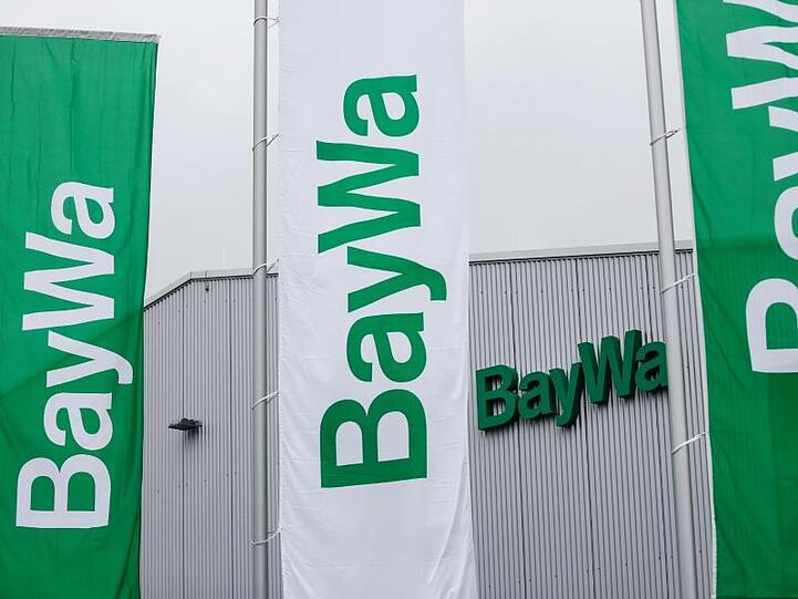 BayWa-Fahnen wehen vor einem neuen Technik-Zentrum des Unternehmens. Foto: David-Wolfgang Ebener/dpa/Archivbild