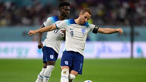 Englands Harry Kane spielt den Ball, dahinter Bukayo Saka.