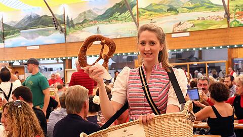 So läuft Sophie durchs Festzelt: Mit ihrem schweren Breznkorb und einem Exemplar in der Hand, das Kunden anlocken soll.