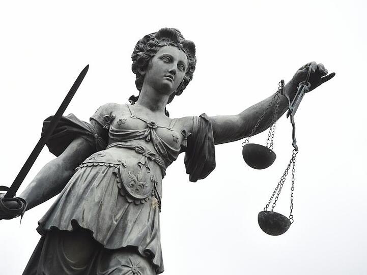 Eine Bronzestatue der Justitia steht in Frankfurt am Main. Foto: Arne Dedert/Archivbild