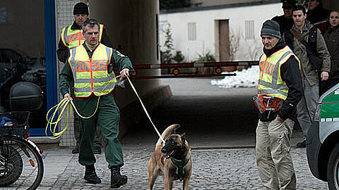 Hundeführer Thomas Schaffer und sein Maintrailer &bdquo;Akki&ldquo;, ein belgischer Schäferhund, am Tatort.