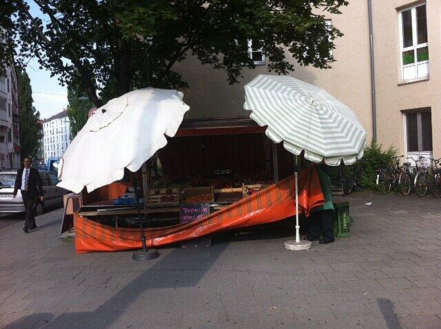 Das Standl hinter Sonnenschirmen.