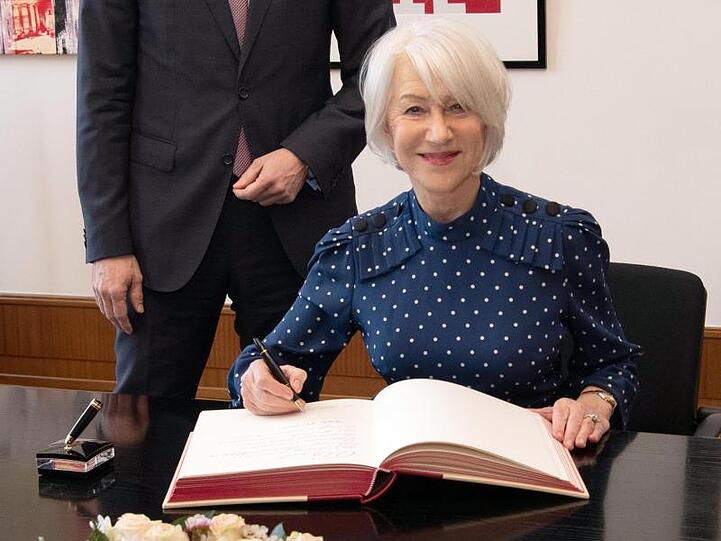 Helen Mirren trägt sich im Roten Rathaus in das Goldene Buch ein.