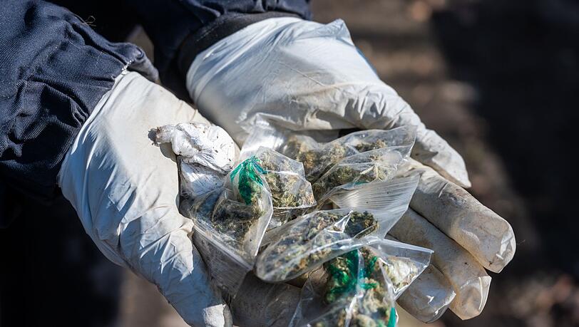 Eine Polizistin hält Tütchen mit Marihuana in den Händen.